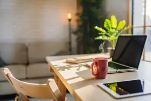 A tidy desk with a laptop and coffee, representative of Lumiora's office cleaning service (stock photo)
