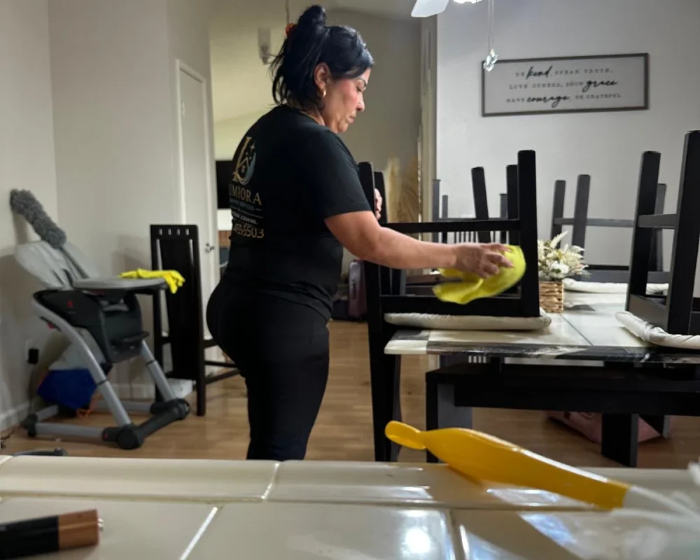 Lumiora team member wiping down dining chairs in a client home