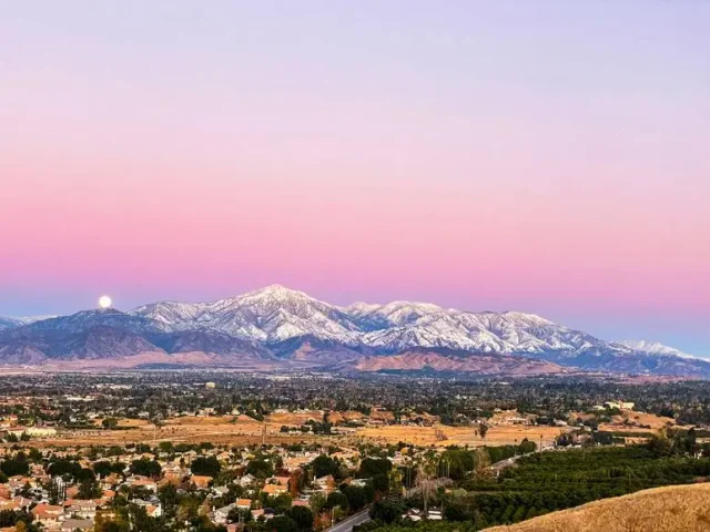 Aerial view of the San Bernardino Valley at sunset with snow-capped mountains